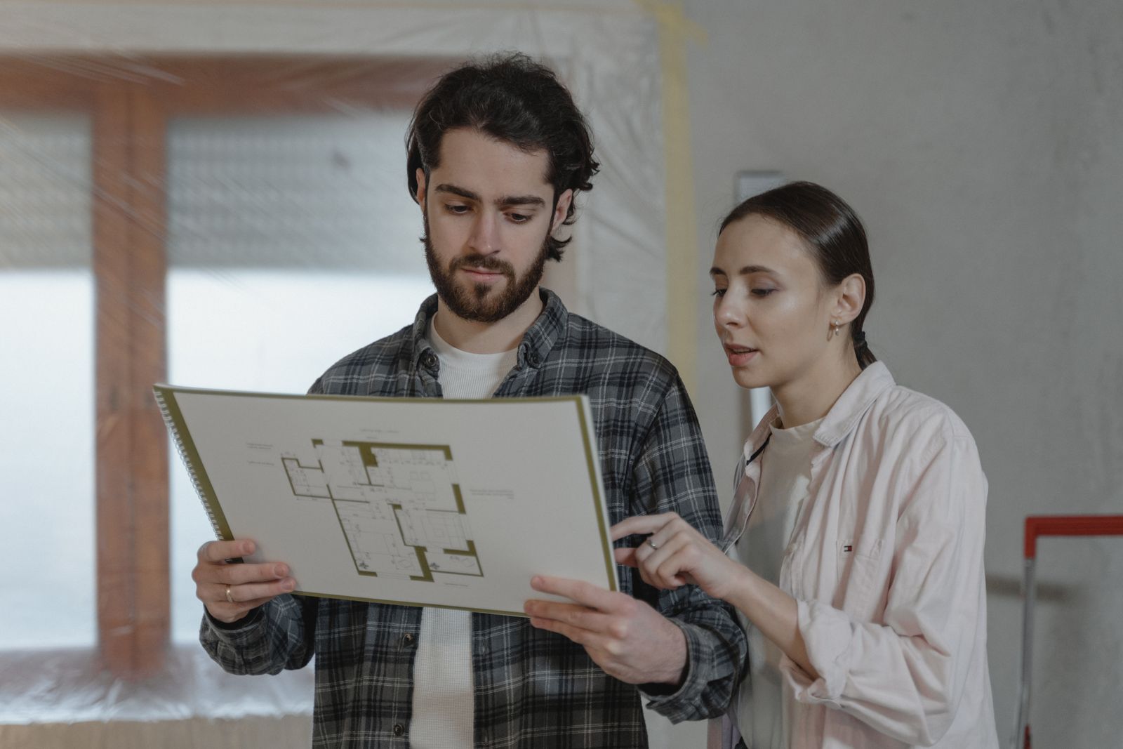 A man and a woman looking over a house floor plan